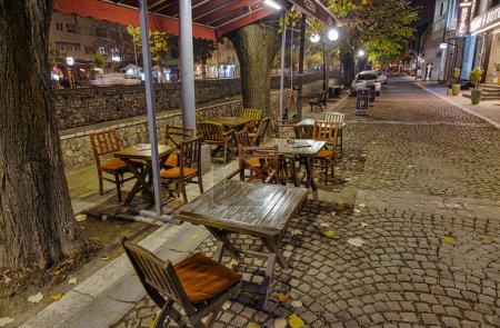 Foto de PREMIO, KOSOVO - 12 DE NOVIEMBRE DE 2022: Las mesas vacías de los restaurantes señalan la llegada de días más fríos por el río Bistrica. - Imagen libre de derechos