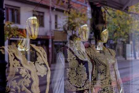Photo for PRIZREN, KOSOVO - NOVEMBER 13, 2022: Dolls in the window of a fashion salon dressed in folk costumes on cloudy November morning. - Royalty Free Image