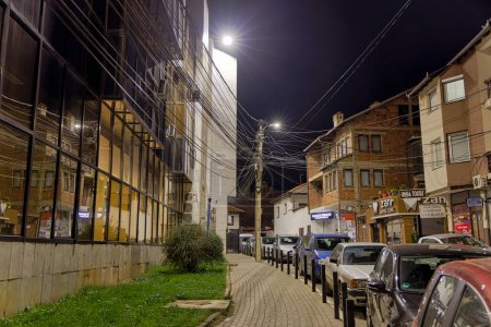 Foto de PREMIO, KOSOVO - 12 DE NOVIEMBRE DE 2022: Un poste eléctrico con un enredo de cables en la nueva calle del casco antiguo en la fría noche de noviembre. larga exposición - Imagen libre de derechos