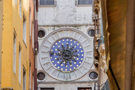 Téléchargez les photos : Une vue unique sur la Tour de l'Horloge nichée parmi les maisons dans une ruelle étroite, marquant l'entrée de la Place Saint-Marks emblématique Venices. - en image libre de droit