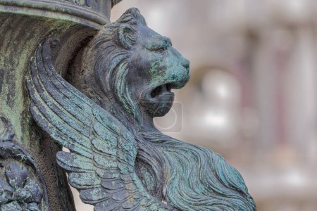 Foto de Primer plano de una detallada escultura de león de metal sobre una columna en la icónica Plaza de San Marcos, Venecia. - Imagen libre de derechos
