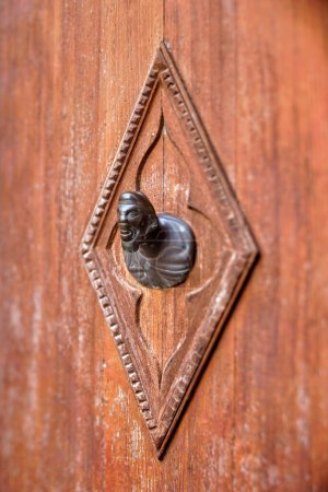 Photo for Ornate brass door handle on ancient doors in Venice, Italy, showing the patina of time, captured with a tilt-shift lens and narrow vertical focus. - Royalty Free Image