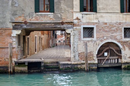 Photo for View through the boat docking port on Calle Berlendis, Venice, revealing the picturesque street until its far end. - Royalty Free Image