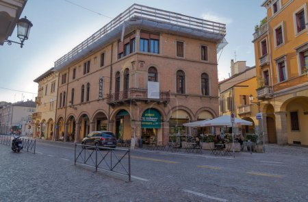 Foto de PADUA, ITALIA - 01 ABRIL 2023: Un antiguo edificio con restaurante y mesas en la calle de Via Beato Luca Belludi. - Imagen libre de derechos