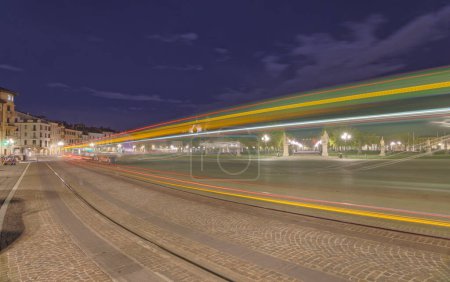 Téléchargez les photos : PADUA, ITALIE - 01 AVRIL 2023 : Longue vue de nuit sur le sentier lumineux d'un tramway au parc Prato della Valle. - en image libre de droit