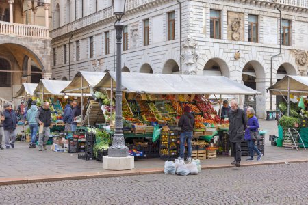 Photo for PADUA, ITALY - APRIL 02 2023: Morning bustle at Piazza della Frutta, with vendors by vegetable and fruit stalls on display. - Royalty Free Image