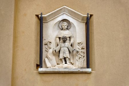 Photo for PADUA, ITALY - APRIL 02 2023: Relief of Saint Anthony protecting children, detailed on an old buildings facade. - Royalty Free Image
