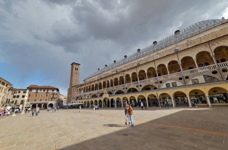 Photo for PADUA, ITALY - APRIL 03 2023: Bustling life at Piazza della Frutta under cloudy skies, with Palazzo della Ragione and the ancient tower - Royalty Free Image