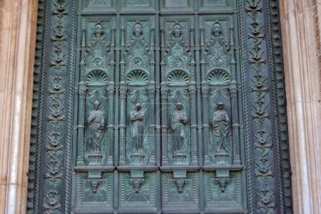 Téléchargez les photos : PADUA, ITALIE - 03 AVRIL 2023 : Vue détaillée des portes en bas-relief en bronze représentant quatre prêtres saints à l'entrée principale de la basilique Saint-Antoine. Plan d'objectif basculant - en image libre de droit