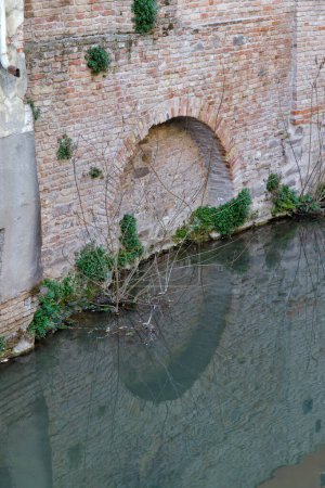 Foto de Vista de una antigua fachada del edificio y un arco reflectante en el canal de agua en Padua Italia. - Imagen libre de derechos