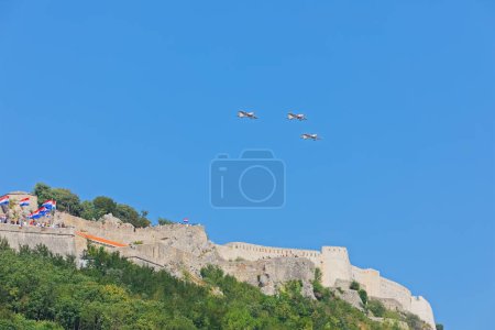 Photo for KNIN, CROATIA - August 5, 2018: Three aircraft from the Krila Oluje aerobatic team soar above the Knin Fortress during Operation Storm celebration. - Royalty Free Image