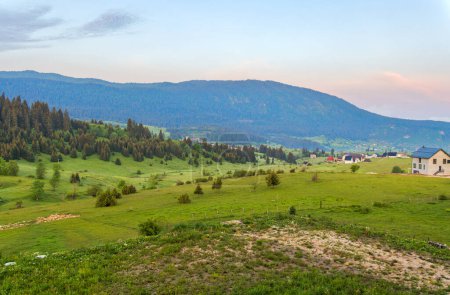 Téléchargez les photos : Vue panoramique imprenable sur les prairies verdoyantes nichées dans les contreforts du mont Vlasic à Travnik, en Bosnie-Herzégovine. - en image libre de droit