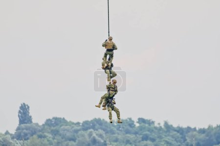 Photo for VARAZDIN, CROATIA - July 21, 2018: Four special police officers swiftly descending using ropes. - Royalty Free Image