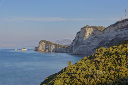Téléchargez les photos : Vue panoramique sur les rochers côtiers du cap Drastis à Corfou, baignés par la lumière douce juste avant le coucher du soleil. - en image libre de droit