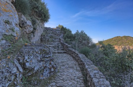 Téléchargez les photos : Des marches sinueuses courbant autour d'une colline, guidant le chemin vers le sommet Angelokastros, château d'Angelos - en image libre de droit