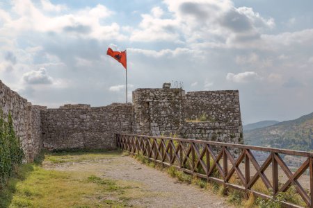 Téléchargez les photos : Détail des murs médiévaux de la forteresse de Rosafa à Shkoder avec le drapeau albanais agitant gracieusement. - en image libre de droit