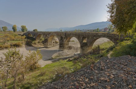 Téléchargez les photos : Vue pittoresque sur le pont Kordhoce, un pont turc ottoman en arc de pierre, à Gjirokaster, en Albanie, par un jour lumineux. - en image libre de droit