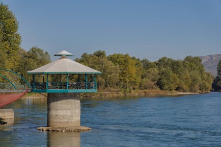Téléchargez les photos : SHKODER, ALBANIE - 19 octobre 2022 : Une vue panoramique avec l'annexe circulaire d'un restaurant niché dans la rivière Drin, mettant en valeur le débit pittoresque de la rivière. - en image libre de droit