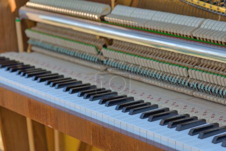 Téléchargez les photos : Détail rapproché du clavier, des cordes et des marteaux anciens du piano conservés - en image libre de droit