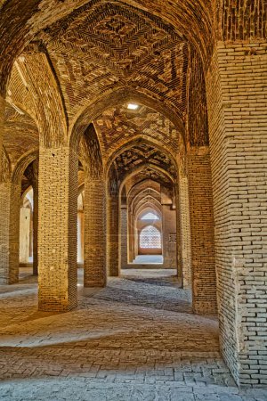 Foto de ISFAHAN, IRÁN - 8 DE MAYO DE 2015: Antigua cámara del Taj al Molk en la Mezquita Jameh hermoso interior con los pilares de ladrillo
. - Imagen libre de derechos