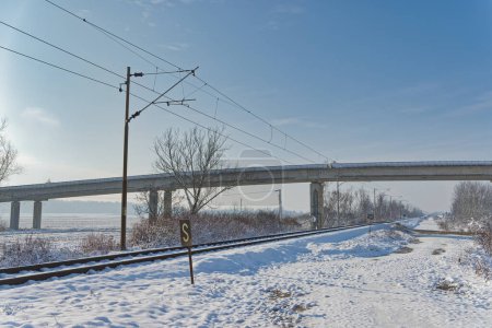Photo for Quiet winter day with snow-covered railway tracks leading under a bridge in the peaceful rural area of Dugo Selo. - Royalty Free Image