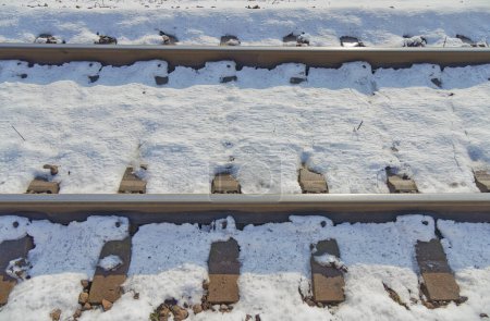 Foto de Un detallado primer plano de las vías férreas cubiertas de nieve que destaca el contraste entre los carriles de acero y la nieve blanca en Dugo Selo. - Imagen libre de derechos