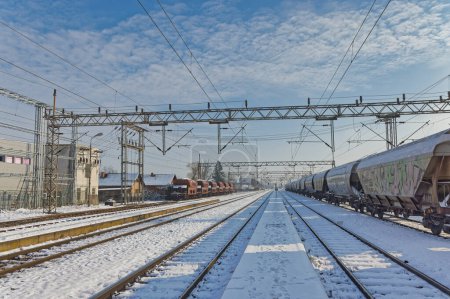 Photo for DUGO SELO, CROATIA - January 25, 2023: Locals near a snow-covered train at Dugo Selo railway station on a bright winter day. - Royalty Free Image