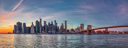 Photo for NEW YORK, USA - OCTOBER 01, 2018: Large stiched panorama of the Manhattan downtown at sunset from the Brooklyn Bridge Park. - Royalty Free Image