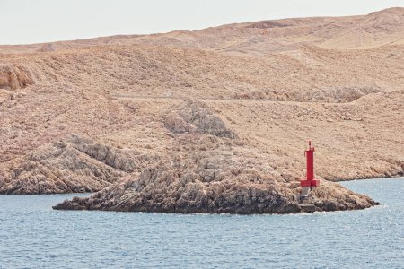 Téléchargez les photos : Vue panoramique d'un phare rouge au port de Zigljen sur le terrain rocheux de l'île de Pag, en Croatie, par une journée ensoleillée. - en image libre de droit