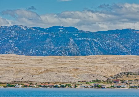 Photo for Breathtaking panorama of the arid Pag Island landscape with Velebit Mountain rising in the distance under the blue sky. - Royalty Free Image