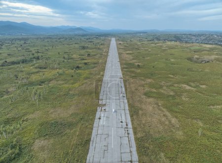 Téléchargez les photos : Vue aérienne de drones surélevés sur la piste abandonnée des bases aériennes de Zeljava, témoin silencieux de l'histoire au milieu d'un paysage tentaculaire. - en image libre de droit