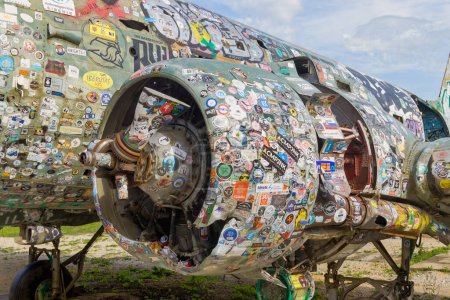 Photo for ZELJAVA, CROATIA - November 6, 2023: The engine of a Douglas C-47 B Dakota at Zeljava Airfield, uniquely decorated with a collection of international stickers. - Royalty Free Image