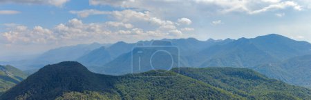 Photo for A majestic landscape encompassing layered mountain ridges covered in dense forests under a sky with scattered clouds, viewed from Ljubicko Brdo. - Royalty Free Image