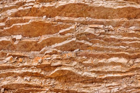 Foto de La imagen muestra la distinta estratificación de las capas de piedra caliza en una cantera, acentuando el rico carácter geológico de esta roca sedimentaria. - Imagen libre de derechos