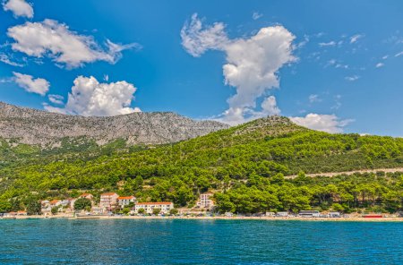 Téléchargez les photos : Vue estivale pittoresque du village de Drvenik avec le massif de Biokovo en arrière-plan, soulignant la beauté naturelle de la côte croate. - en image libre de droit