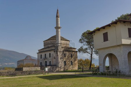 Téléchargez les photos : IOANNINA, GRÈCE - 17 août 2023 : La mosquée Fethiye, un exemple d'architecture ottomane classique avec son minaret en pierre, se dresse sous le ciel bleu à Ioannina. - en image libre de droit