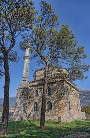 Photo for IOANNINA, GREECE - October 23, 2023: The historic Fethiye Mosque stands with its impressive minaret amidst the greenery under the clear blue sky in Ioannina. - Royalty Free Image