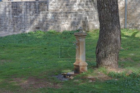 Foto de IOANNINA, GRECIA - 23 de octubre de 2023: Una fuente de piedra ornamentada, un remanente de la época otomana, se encuentra silenciosamente cerca de la Mezquita Fethiye en el tranquilo entorno de Ioannina. - Imagen libre de derechos