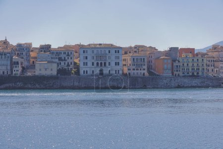 Téléchargez les photos : CORFU, GRÈCE - 21 octobre 2022 : Bâtiments vibrants bordant le front de mer de la ville de Corfou sous un ciel bleu clair - en image libre de droit