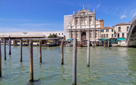 Photo for VENICE, ITALY - APRIL 10 2023: People walking past the Church of Santa Maria of Nazareth as viewed from across the Grand Canal. - Royalty Free Image