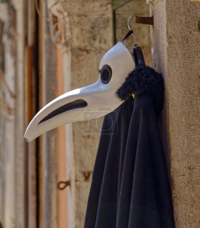 Photo for VENICE, ITALY - APRIL 10 2023: A plague mask displayed at a souvenir shop amidst the vintage charm of Canal Street in the old town. - Royalty Free Image
