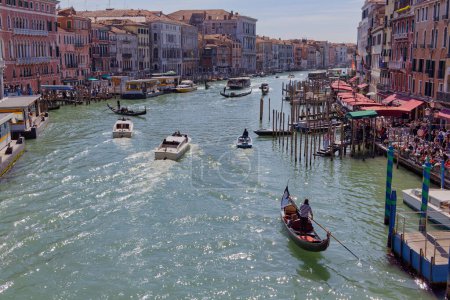 Photo for VENICE, ITALY - APRIL 10 2023: A boats transporting tourists passing beautiful facades of old houses lining the Grand Canal. - Royalty Free Image