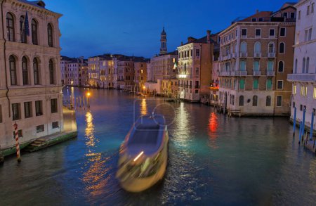 Foto de VENECIA, ITALIA - 10 ABRIL 2023: Un crepúsculo sereno desciende sobre el Gran Canal, proyectando un suave y místico resplandor que realza la atmósfera romántica. - Imagen libre de derechos