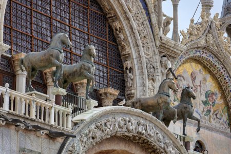 Foto de VENECIA, ITALIA - 11 ABRIL 2023: Caballos de Bronce elementos decorativos en la fachada de la Basílica de San Marcos, que ofrece una visión de rico patrimonio arquitectónico. - Imagen libre de derechos
