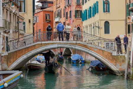 Photo for VENICE, ITALY - APRIL 11 2023: Small crossing arch bridge in a canal street, embodying the quintessential old town charm. - Royalty Free Image