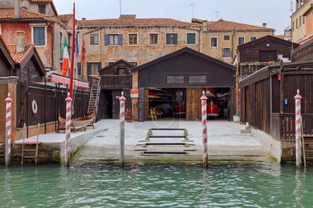 Photo for VENICE, ITALY - APRIL 11 2023: A unique view of a gondola storage and repair workshop, alongside a boat garage and dry dock. - Royalty Free Image