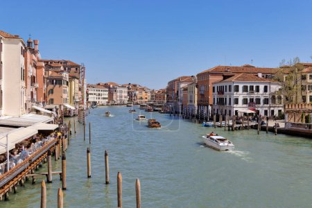 Photo for VENICE, ITALY - APRIL 10 2023: Boats passing the Grand Canal view from Stone Arch bridge Ponte degli Scalzi. - Royalty Free Image