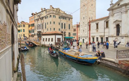 Téléchargez les photos : VENISE, ITALIE - 11 AVRIL 2023 : Un gondolier parcourt habilement un canal sinueux du centre historique de Venices, offrant un aperçu du charme intemporel de cette ville emblématique. - en image libre de droit