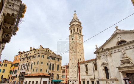 Foto de VENECIA, ITALIA - 11 ABRIL 2023: Belleza intemporal de la arquitectura veneciana, con una antigua torre de la iglesia y edificios históricos. - Imagen libre de derechos