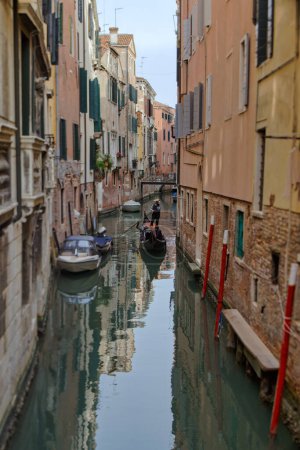 Foto de VENECIA, ITALIA - 11 ABRIL 2023: Un gondolero navega hábilmente por un sinuoso canal en el centro histórico de Venices, ofreciendo un vistazo al encanto atemporal de esta icónica ciudad. lente de desplazamiento basculante - Imagen libre de derechos